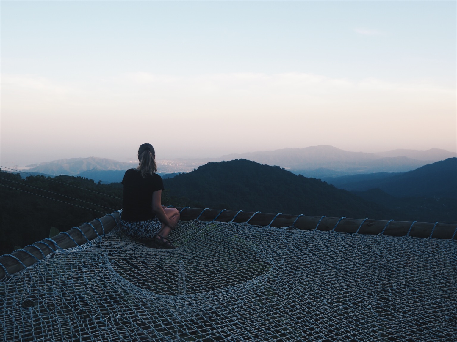 Girl in a giant hammock overlooking beautiful scenery