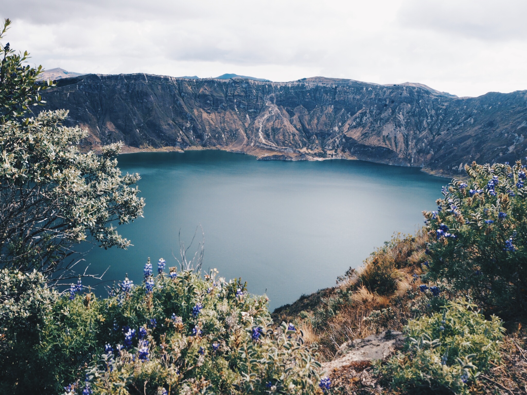 Laguna Quilotoa and mountains with vegetation in front